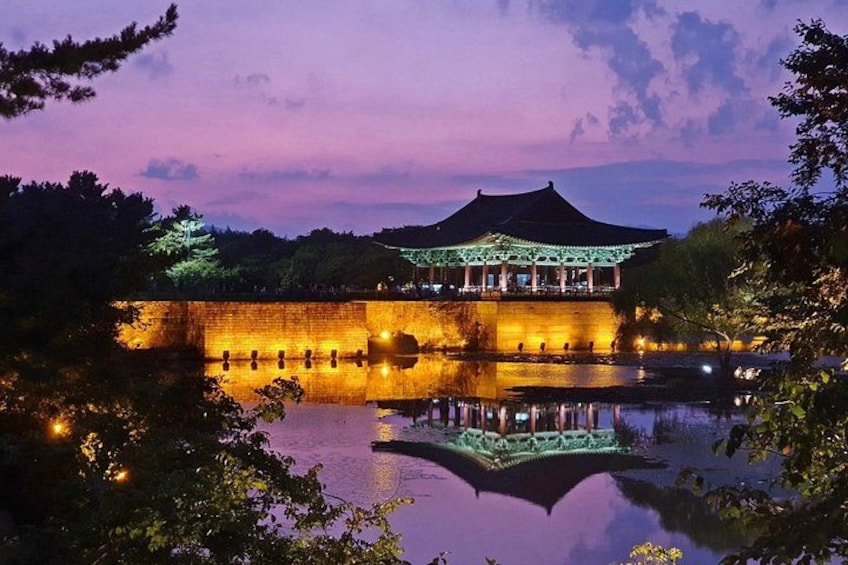 A traditional pavilion by a calm lake at dusk. 4