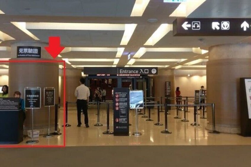 An airport entrance with a sign indicating 'Entrance' and a red arrow pointing towards it. 3