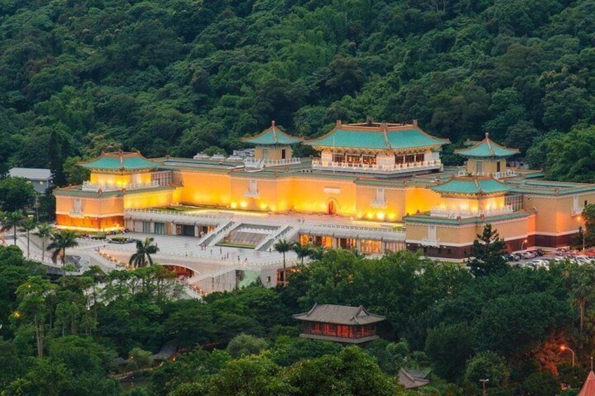 A traditional multi-tiered building with a green roof, surrounded by lush greenery. 1
