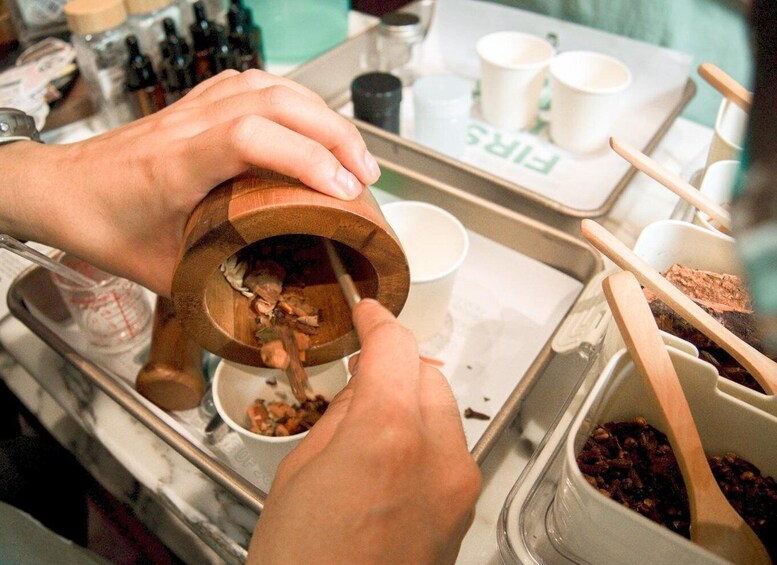 A person grinding spices using a wooden mortar and pestle. 5