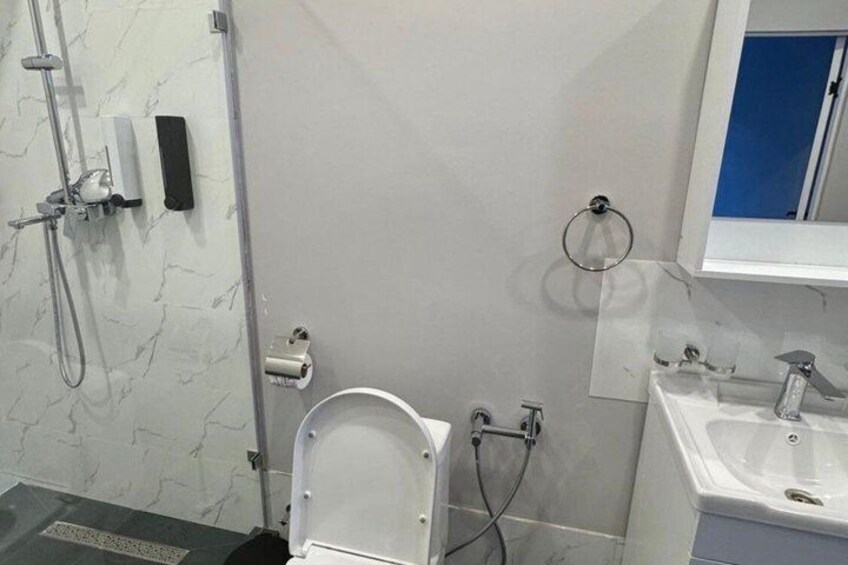 A modern bathroom with a toilet, bidet, and sink. 4