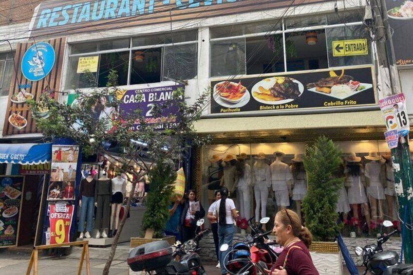 A restaurant with a signboard advertising dishes like 'Parrillada' and 'Bisteck a la Pobre'. 5