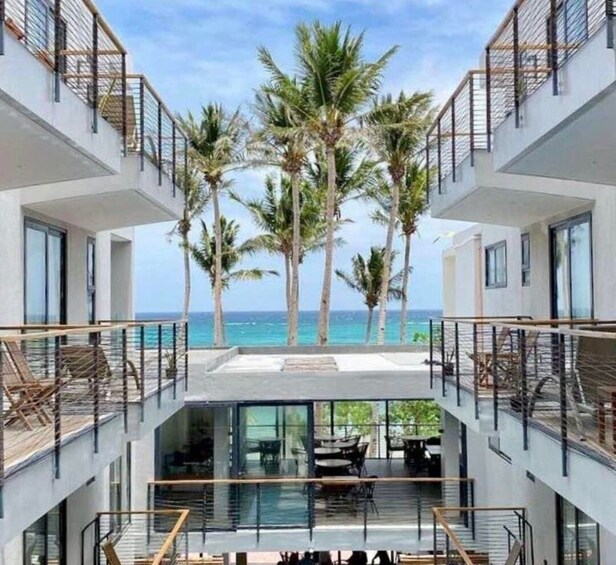 A modern multi-story building with a pool and palm trees. 1