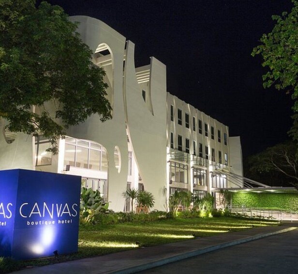 A modern building with a unique architectural design, surrounded by well-maintained greenery and a clear night sky. 2