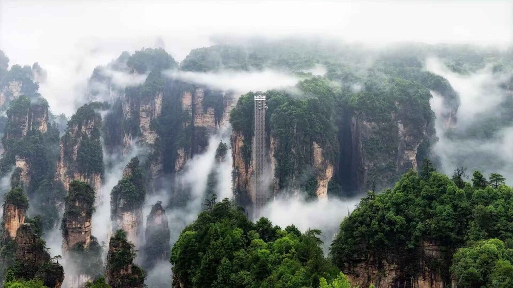Towering limestone cliffs, dense forest, and misty atmosphere. 5