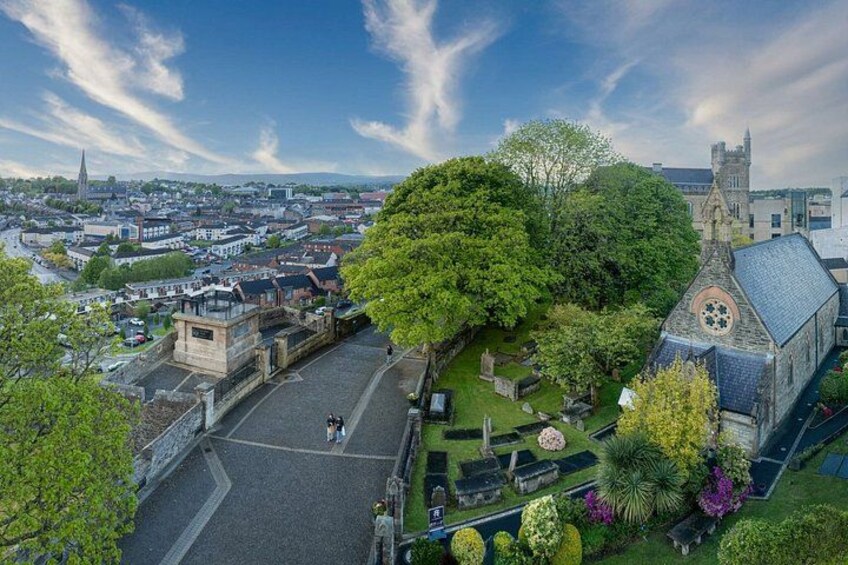 A town with a prominent church, a large tree, and a cemetery. 3
