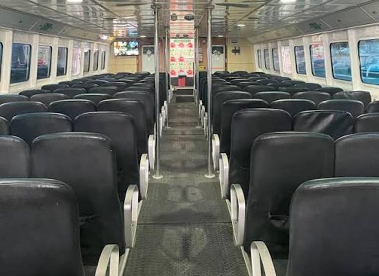 A train interior with rows of black seats and windows on both sides. 2