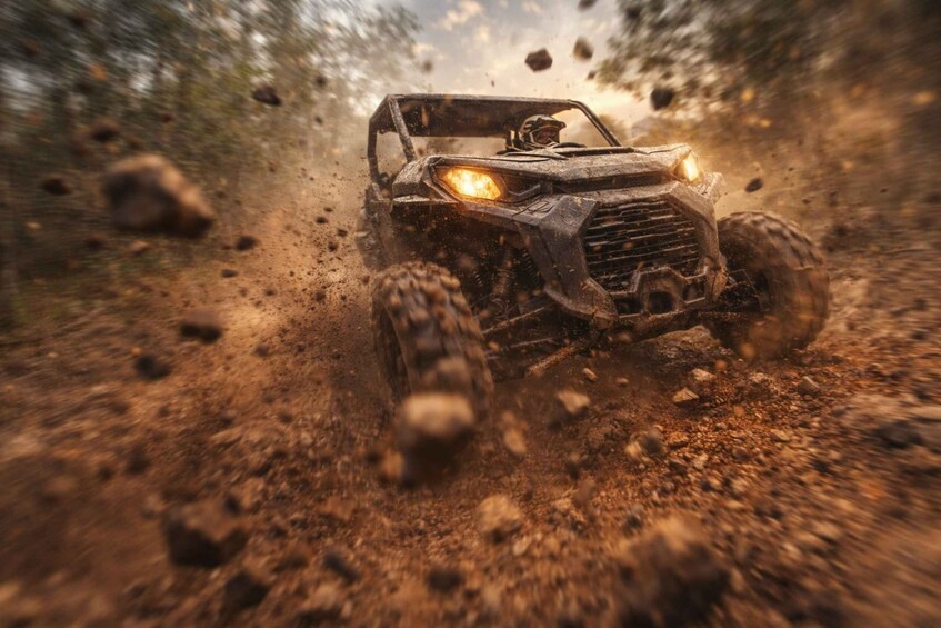 A vehicle driving through a rugged, rocky terrain with a driver visible. 5