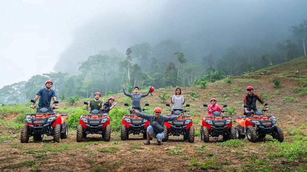 A group of people on ATVs in a misty, hilly outdoor setting. 1