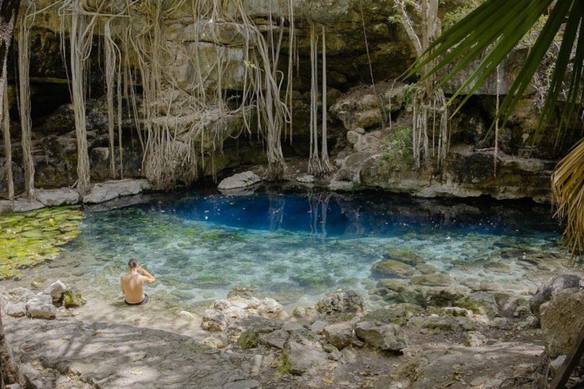 A clear blue pool surrounded by rocks and vegetation. 2