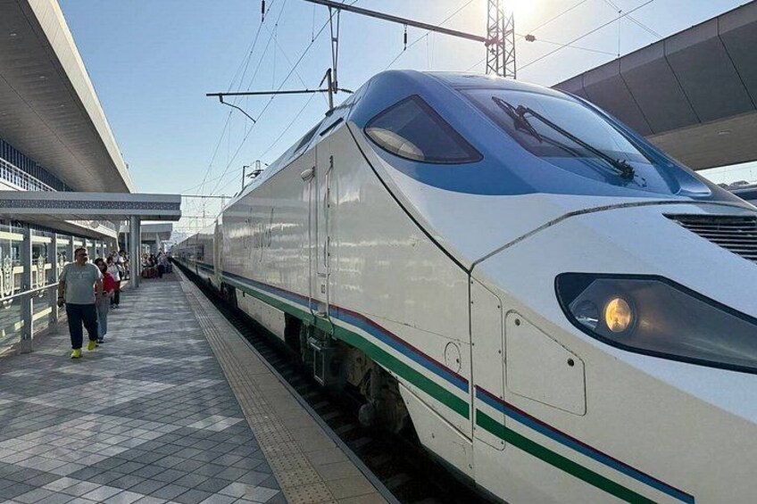 A high-speed train at a station platform with passengers waiting. 2