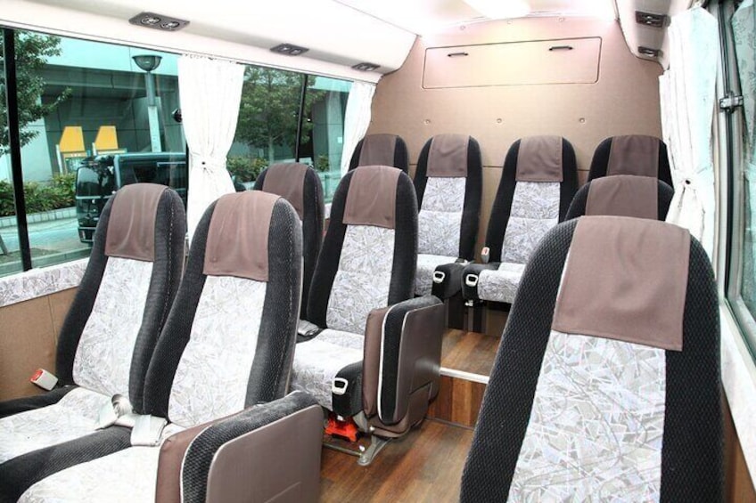 A bus interior with rows of seats, a window, and a door. 3
