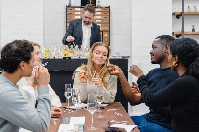 A group of people sitting around a table with wine glasses, engaged in conversation. 5
