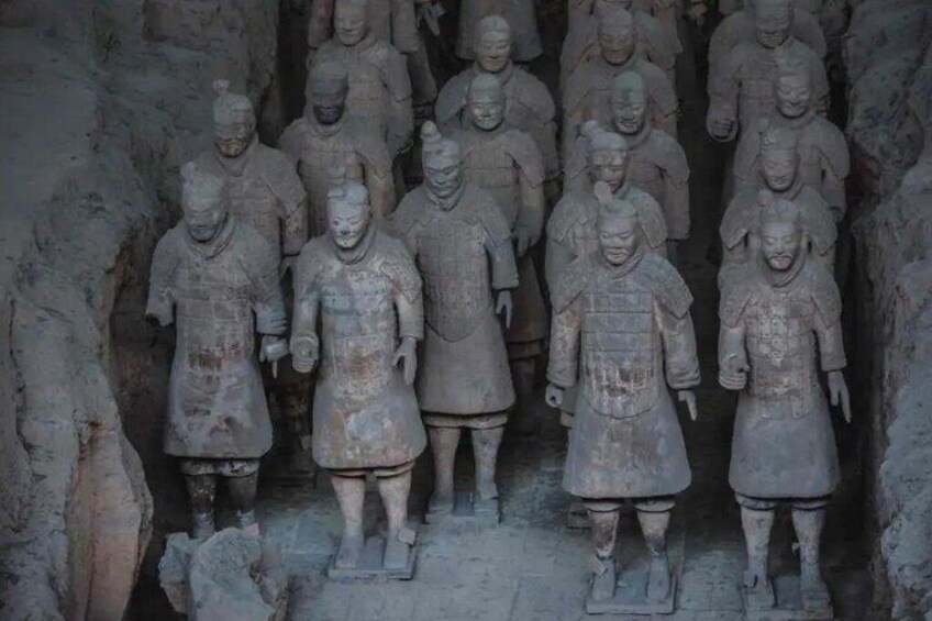 A row of ancient terracotta warrior statues in a cave. 4