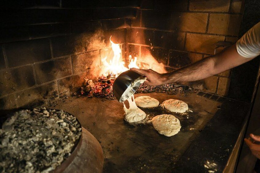 A person cooking food over an open fire in a brick oven. 3