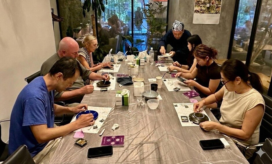 A group of people engaged in a pottery-making activity around a table with clay, tools, and pottery pieces. 1