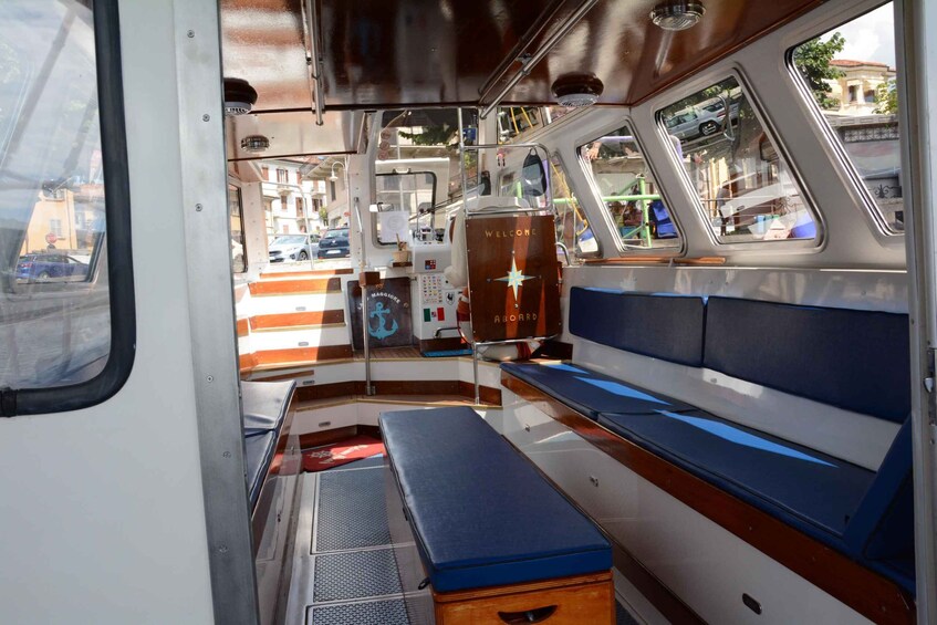 The interior of a boat with a bench, control panel, and windows. 3