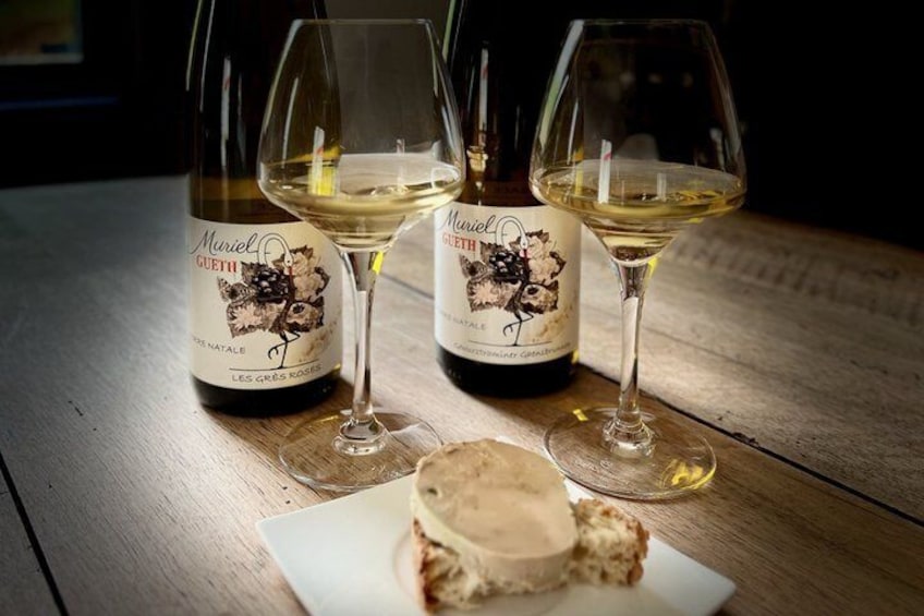 Three bottles of wine and two wine glasses on a wooden table. 1