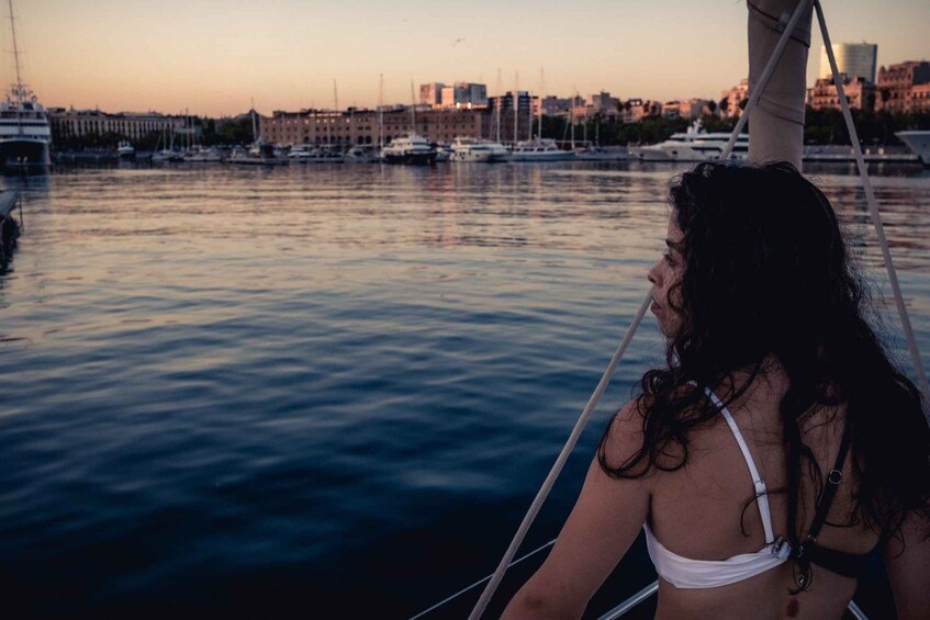 A person on a sailboat with a cityscape in the background. 5