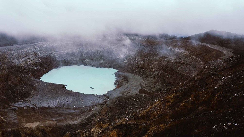 A volcanic crater with a small lake surrounded by rugged terrain. 2
