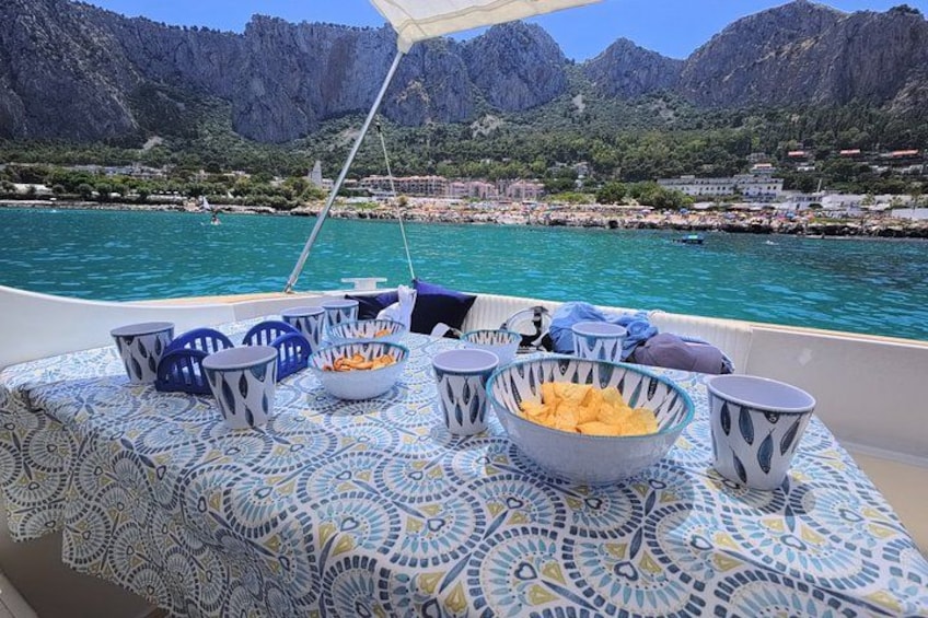 A boat with a table set for dining, surrounded by a mountainous landscape and a body of water. 4