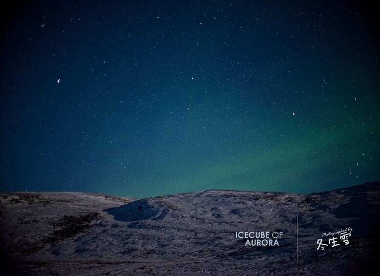 A night sky with stars and the aurora borealis over a rocky landscape. 5