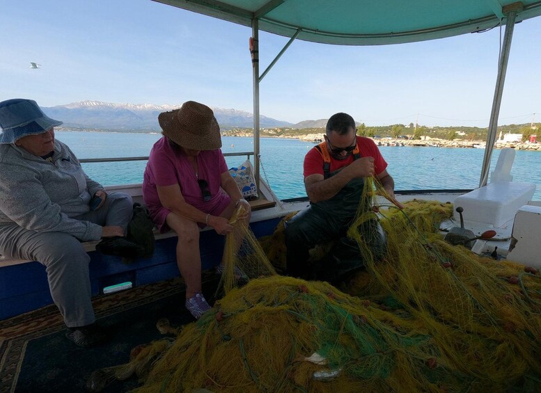 Three people on a boat handling fishing nets. 2