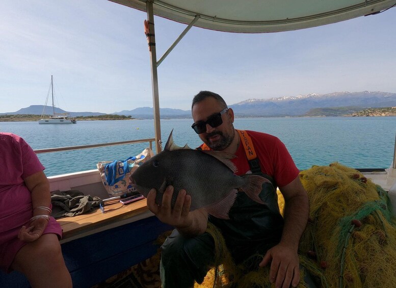 A person holding a fish on a boat with a mountainous landscape in the background. 5