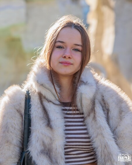 A person wearing a fur coat and carrying a bag. 2