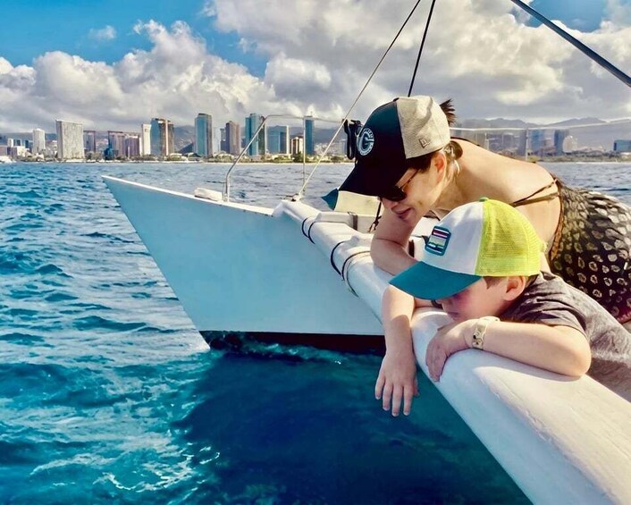 A person leaning on a boat's edge with a city skyline in the background. 5