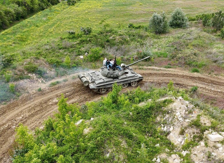 A military tank on a dirt road surrounded by greenery. 4