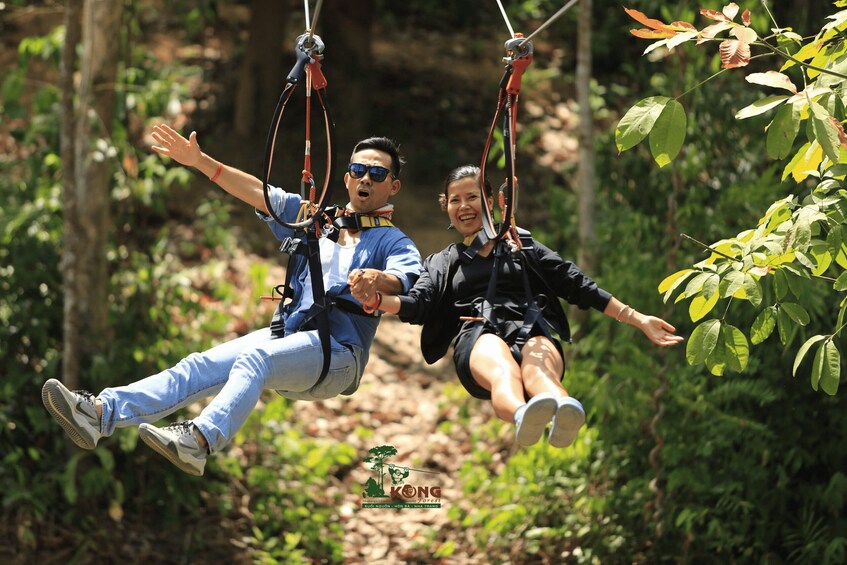 To personer på en zipline i en skov. 2