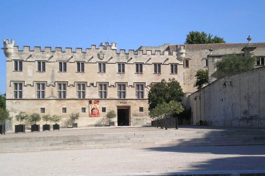A historic building with a symmetrical facade, a central entrance, and a courtyard. 2