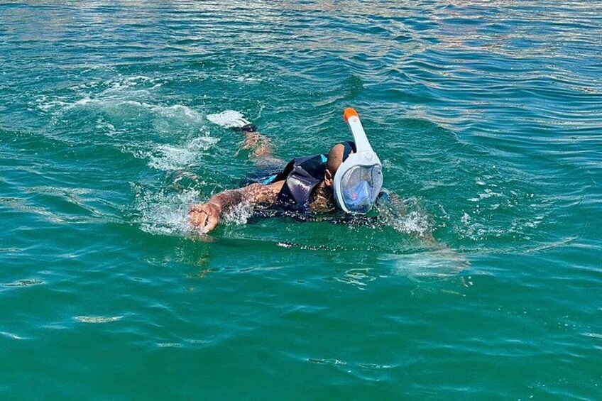 A person snorkeling in clear blue water. 4
