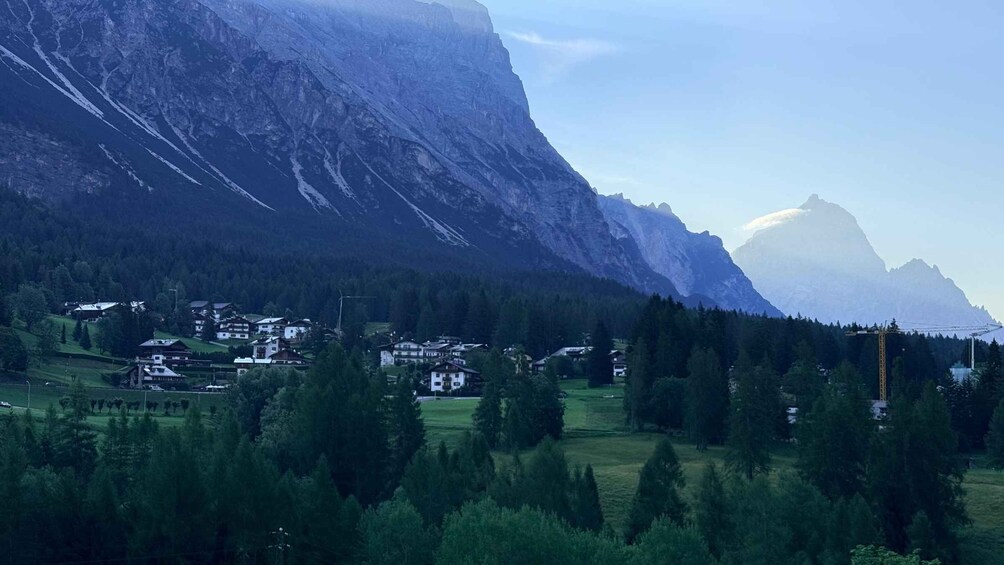 A mountainous landscape with a village nestled among trees. 3