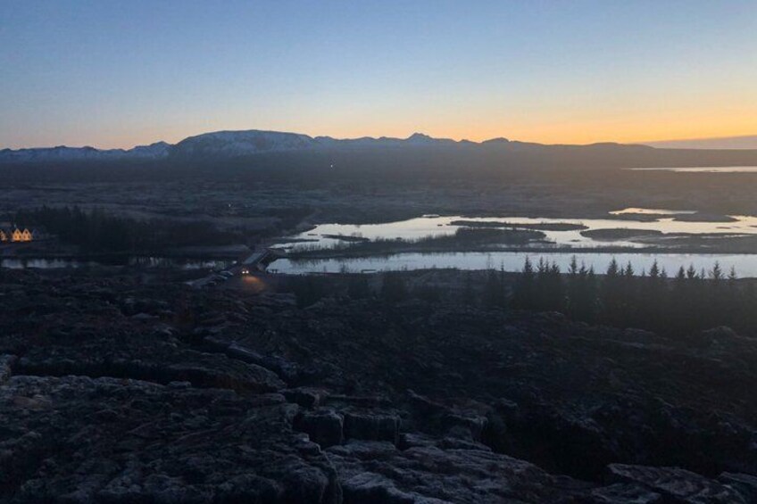 A mountainous landscape with a lake and a small settlement at dusk. 3