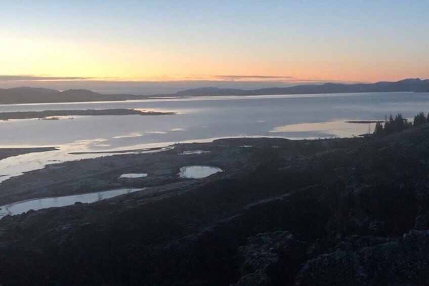 A mountainous landscape with a large body of water and distant hills. 2