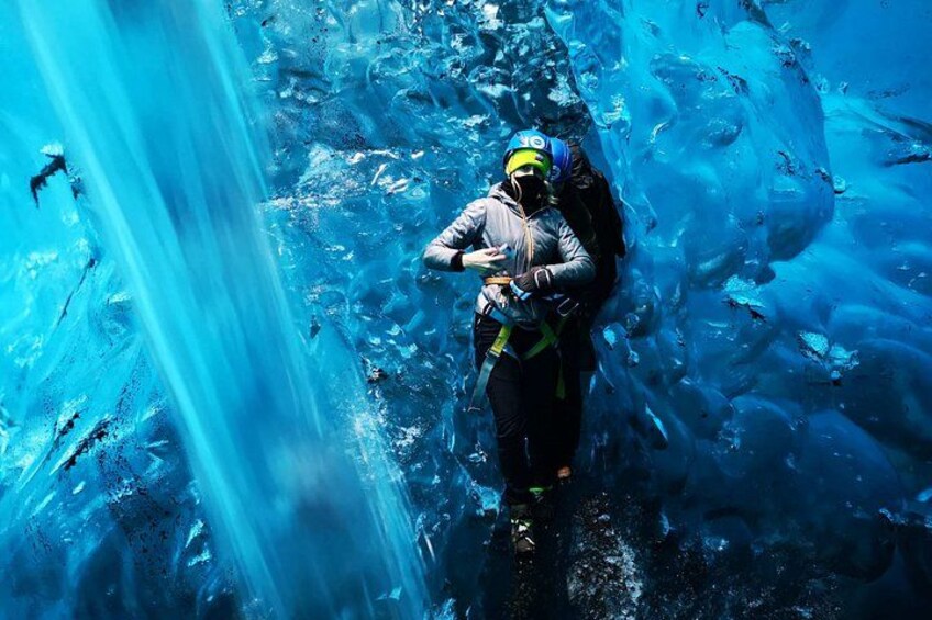 A person climbing a glacier with a backpack. 3