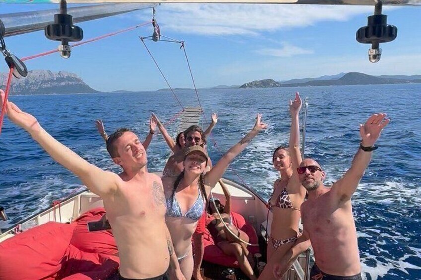 A group of people on a boat with the sea and a distant island in the background. 2