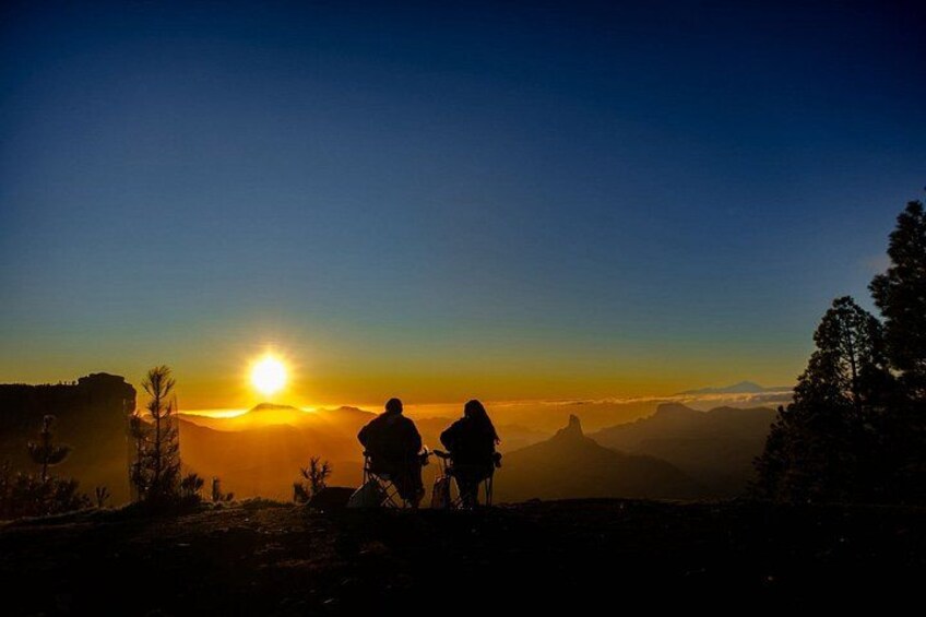 A sunset with two hikers silhouetted against the sky. 4