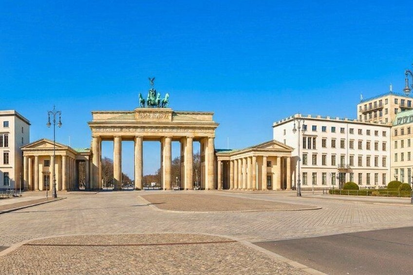 The Brandenburg Gate in Berlin, surrounded by classical architecture and a clear blue sky. 3