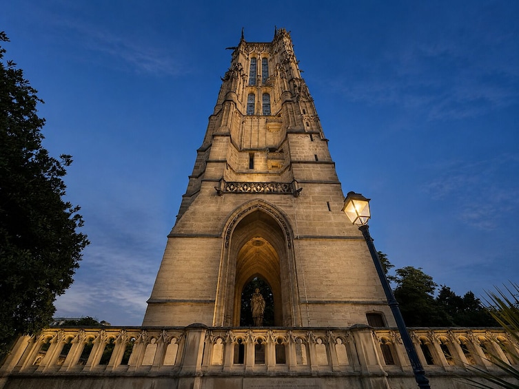 A Gothic-style tower with intricate stonework and a statue at the base. 3