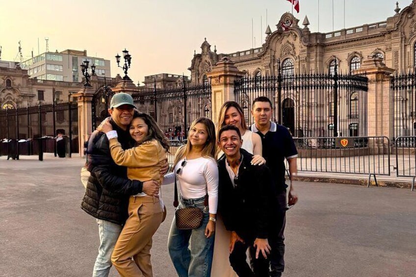 A group of people in front of a historic building with ornate architecture. 1