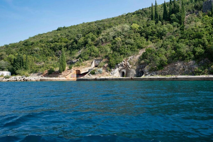 A coastal landscape with a rocky outcrop, a small building labeled 'POLIS,' and a clear blue sea. 5