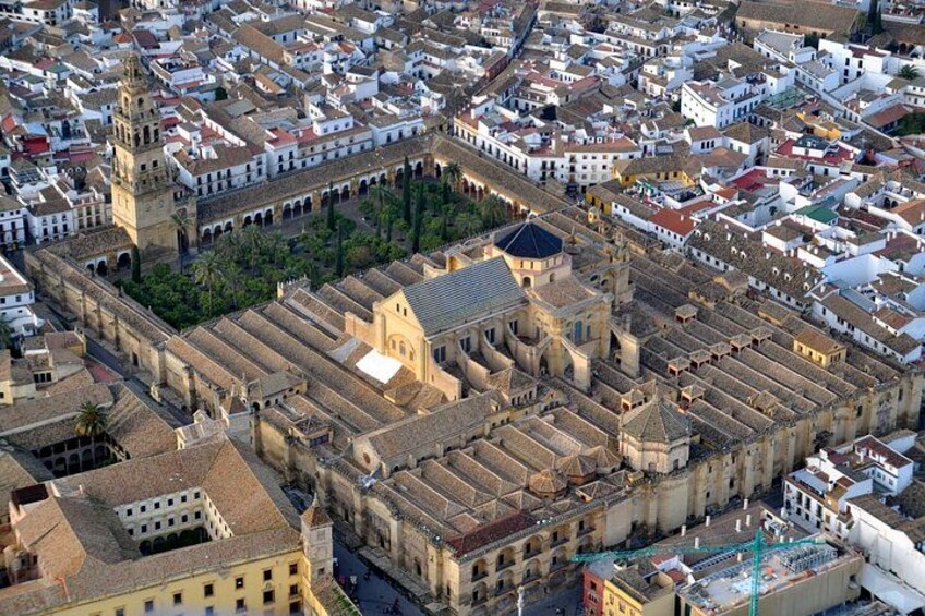 An aerial view of a historic city center with a prominent church, narrow streets, and dense urban architecture. 4