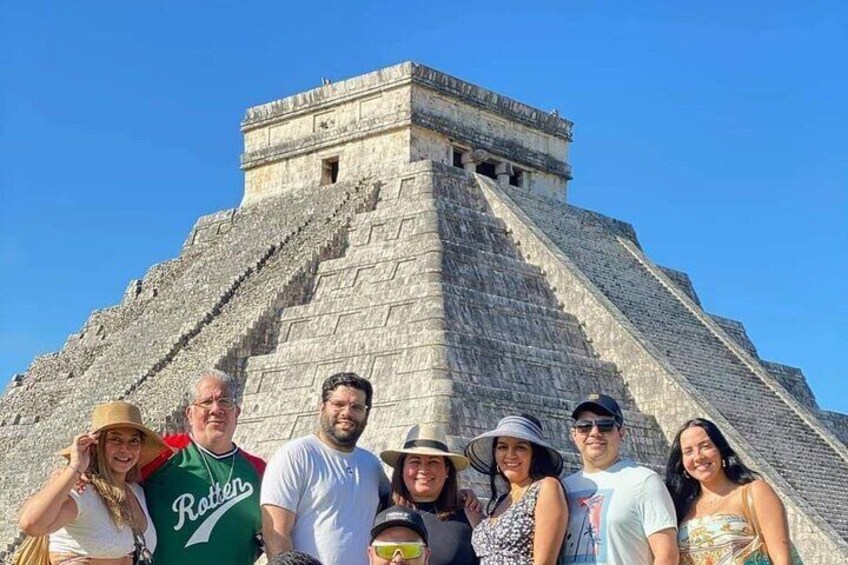 A group of people standing in front of a large pyramid-like structure. 5