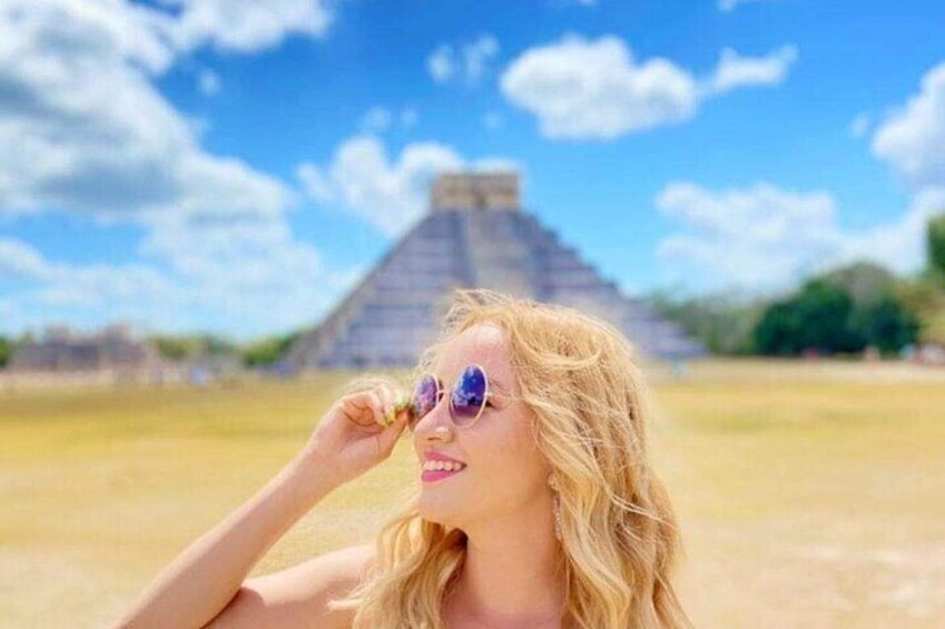 A person with sunglasses in front of a pyramid. 3