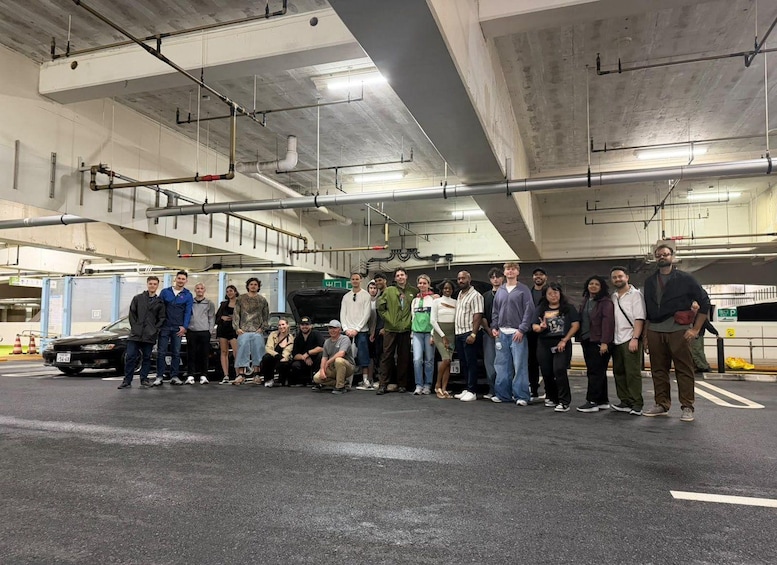 A group of people standing in an indoor parking garage. 3
