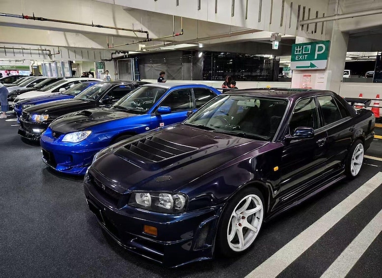 A row of sports cars parked in a garage. 2