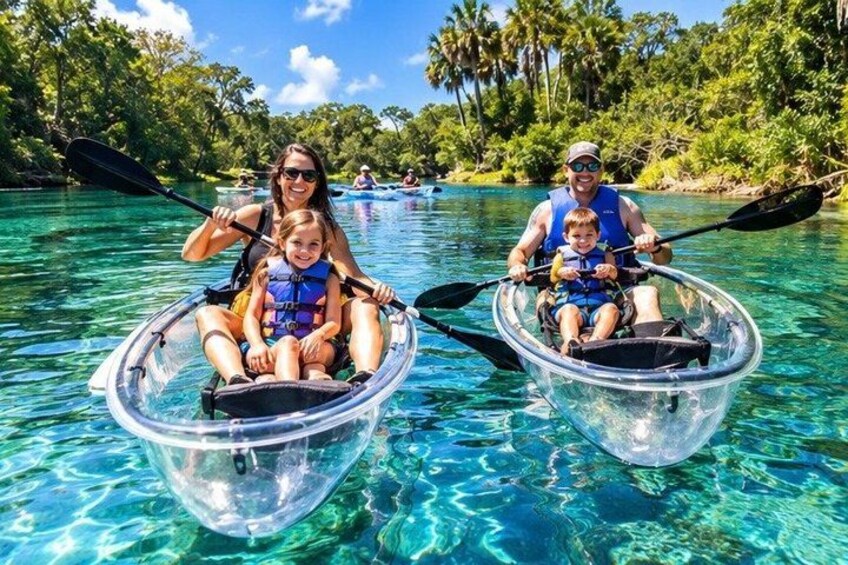 Two people in clear plastic kayaks on a clear blue water body surrounded by greenery. 5